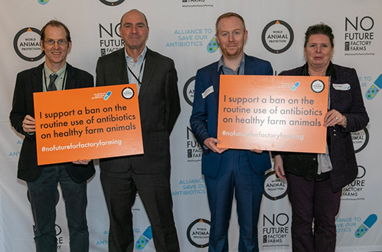 Board members of Alliance to Save Our Antibiotics, Soil Association, and CIWF pose with pledge cards at parliamentary reception.