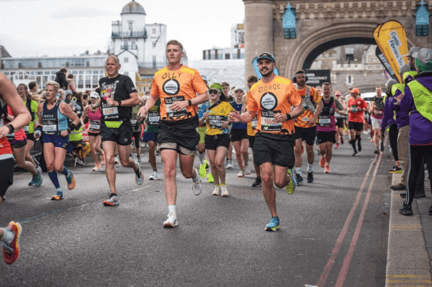 London Marathon runners running across tower bridge. The two runners at the front are wearing World Animal Protection t-shirts.