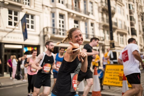 A group of runners participates in a London race, surrounded by historic buildings.