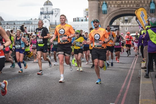 London Marathon runners running across tower bridge. The two runners at the front are wearing World Animal Protection t-shirts.