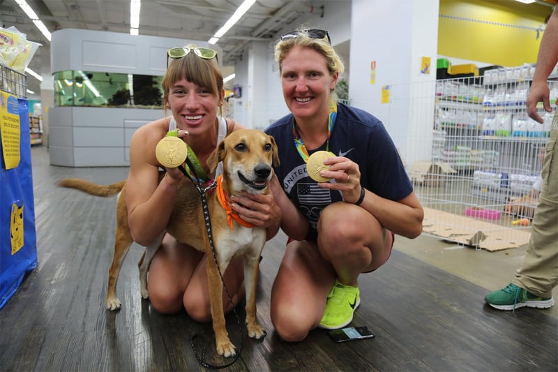 Athena the dog with two Olympic gold medallists at our dog adoption event in Rio