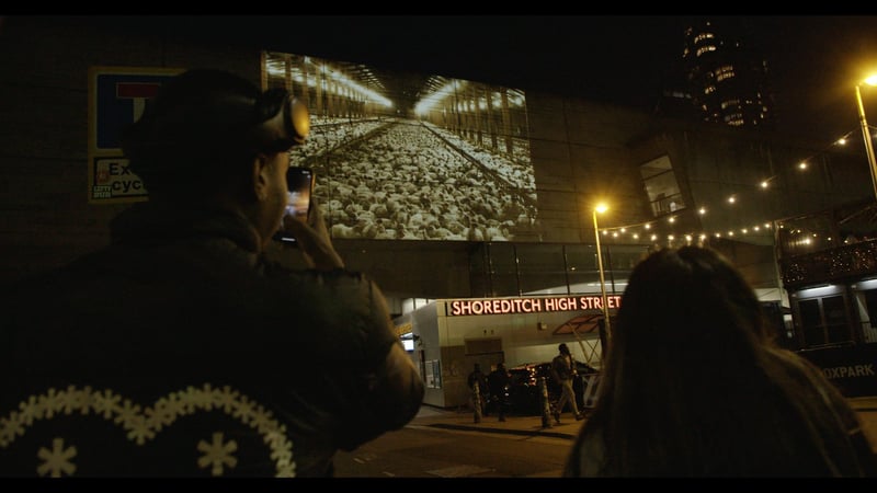 A barn full of chickens living in horrific conditions is projected onto Shoreditch High Street station