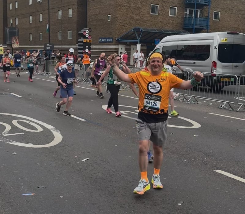 A London Marathon runner is wearing an orange World Animal Protection t-shirt.