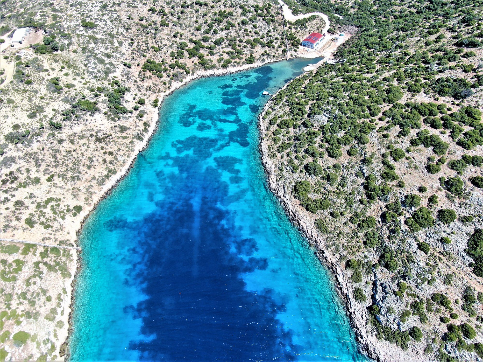 An aerial photograph of a clear, turquoise-coloured body of water
